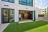Contemporary apartment with a spacious gym opening onto a lush green courtyard, featuring floor-to-ceiling windows for abundant natural light.