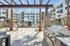 Modern outdoor patio at apartment complex featuring a sleek barbecue grill, stylish pergola, and inviting pool area, perfect for entertaining.