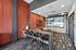 Chic apartment lounge with modern bar seating, vibrant artwork, and scenic wall decor.