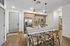 Inviting modern kitchen with sleek appliances, wooden cabinetry, and chic pendant lighting, complemented by a stylish dining area with comfortable seating.