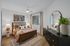 Elegant bedroom with stylish wooden bed, cozy bedding, artistic decor, and modern furnishings.