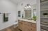 Elegant bathroom design featuring a spacious vanity with wood cabinetry, modern lighting, and stylish decor elements.
