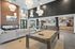 Chic community lounge featuring a cozy sofa, stylish lighting, billiards table, and modern kitchen with seating area, perfect for social gatherings.