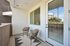 Charming apartment balcony featuring stylish seating and a cozy rug, perfect for relaxation and outdoor enjoyment.