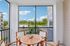 Charming balcony with wooden furniture and expansive views of lush greenery, perfect for relaxation and outdoor dining.