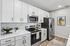 Modern kitchen with sleek white cabinetry, stainless steel appliances, and elegant decor, perfect for contemporary living.