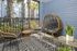 Chic apartment balcony with wicker furniture, tropical plants, and vibrant outdoor setting.