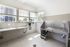 Bright and modern pet grooming station with stainless steel fixtures and convenient windows for natural light.