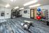 Modern fitness center with vibrant flooring, equipped with exercise machines, weight training area, and colorful gym balls for a dynamic workout experience.