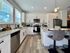 Bright and modern kitchen with sleek granite countertops, white cabinetry, and stainless steel appliances, offering a stylish and functional space for culinary creativity.