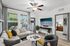 Charming living room with modern decor, a cozy sectional sofa, vibrant cushions, elegant marble coffee table, and large windows bringing in natural light.