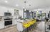 Stylish open-concept kitchen and living area featuring sleek white cabinets, granite countertops, and vibrant yellow bar stools.