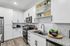Contemporary kitchen with sleek white cabinetry and granite countertops, featuring modern stainless steel appliances and stylish open shelving.