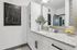 Elegant bathroom showcasing a sleek granite countertop, modern fixtures, and stylish black and white abstract art.