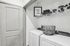 Chic and efficient laundry room with modern washer and dryer, organized shelving, and playful decor.