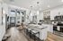 Modern open-concept living area featuring a stylish kitchen with granite countertops, cozy breakfast bar, and spacious living room with large windows and elegant decor.