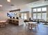 Bright and modern community lounge featuring sleek computer stations, cozy seating, and abundant natural light.
