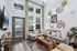 Bright and inviting living room featuring high ceilings, elegant decor, and cozy seating with a view through tall windows.