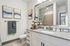 Modern bathroom featuring a granite countertop, stylish artwork, and elegant fixtures creating a chic and inviting space.
