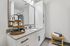 Elegant bathroom with granite countertop, modern fixtures, and ample storage, featuring a stylish towel rack and decorative accents.