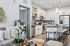Bright, modern open-concept kitchen and living room with sleek white cabinetry, stainless steel appliances, and elegant decor.