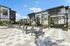 Elegant outdoor recreation area with modern lounge chairs, shaded seating, and lush greenery, perfect for relaxation.