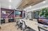 Modern co-working space with sleek computers, vibrant shelving, and a spacious conference table, perfect for productivity and creativity.