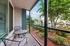Charming screened-in patio with cozy seating and lush garden views, perfect for relaxing outdoors.