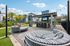 Chic outdoor lounge area with stylish round seating, lush palm trees, and a modern pergola, perfect for relaxation and entertainment.