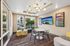 Modern lounge area with vibrant artwork, stylish pendant lighting, and comfortable seating, offering a welcoming atmosphere and scenic views.