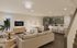 Sophisticated open-concept living space showcasing elegant furniture, modern kitchen with sleek appliances, and inviting dining area at Slate Springdale.