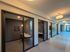 Modern apartment hallway with sleek glass-walled offices, warm lighting, and contemporary decor.