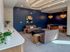 Inviting modern lounge with sleek furniture, artistic wall accents, and warm lighting, perfect for relaxation and social gatherings.