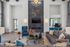 Luxurious modern living room with high ceilings, a sleek fireplace, elegant lighting, and stylish decor featuring vibrant accents.