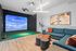 Contemporary entertainment room featuring a high-tech sports simulator, chic modular seating, and modern decor for ultimate relaxation and fun.