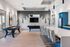 Modern entertainment space with sleek pool table, shuffleboard, elegant bar seating, and contemporary decor.
