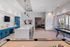 Chic and modern recreation room featuring a sleek bar counter, vibrant blue cabinetry, sophisticated pendant lighting, and a pool table, ideal for social gatherings.