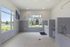 Modern pet wash station with sleek grey tile walls, ample windows allowing natural light, and convenient fixtures.