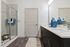 Modern bathroom featuring sleek double vanity with elegant dark cabinets, stylish glass walk-in shower, and decorative blue vases, offering a luxurious feel.