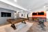 Luxurious game room featuring a sleek pool table, modern foosball table, and vibrant decor, perfect for entertainment and relaxation.