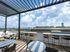 bartop tables on rooftop deck overlooking city on sunny day