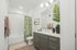bathroom with tub and shower combo with grey cabinets