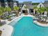 Pool with lounge chairs and exterior of apartments