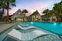 Pool with lounge chairs and exterior of clubhouse at twilight