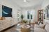 furnished living area with couch, coffee table, window and television on console table