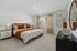 Furnished primary bedroom with large bed and side tables