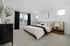 Furnished primary bedroom with large bed and side tables