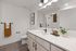 Furnished Bathroom with light wood cabinets and large vanity