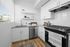 Furnished kitchen with white cabinets