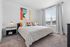 furnished bedroom with large window and bed